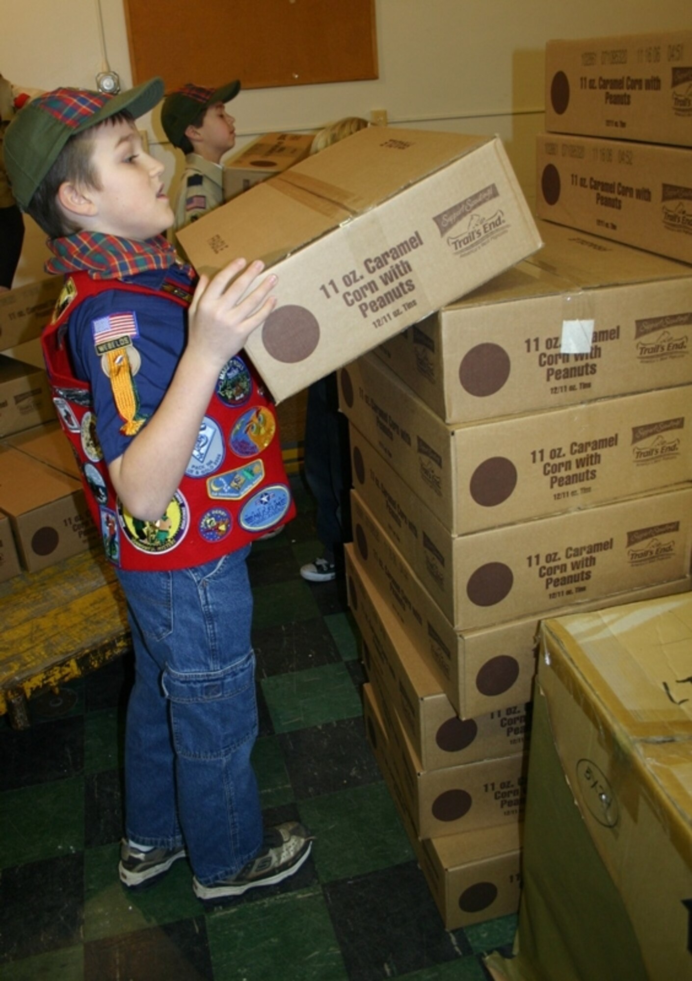 Luke D'Alfonso, Cub Scout Pack 199, helps unload boxes of caramel popcorn for the Red Cross at a warehouse at Fort Dix. The Boy Scouts and Cub Scouts of Burlington County, including McGuire Pack 199, sold “Scouts support our troops” car magnets in return for tins of caramel popcorn to be sent to deployed troops. U.S. Air Force photo by Airman Rebekah Phy