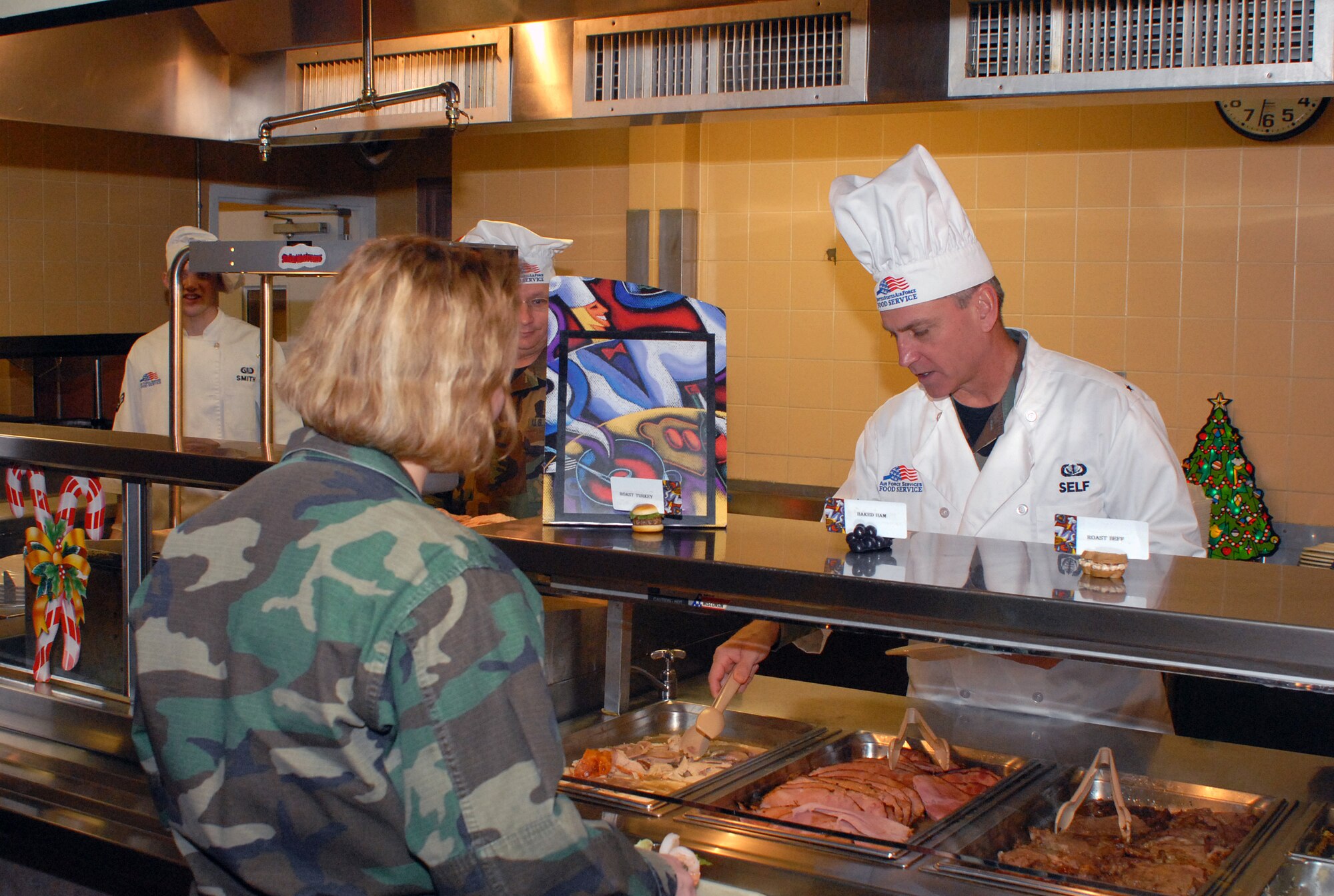 Brig. Gen. Kip Self, 314th Airlift Wing commander, serves food to Airmen at the dining facility Christmas Day. Each year, commanders serve the Airmen at the dining facility to share the special day with base Airmen and thank them for their service. (Photo by Airman 1st Class Nathan Allen)