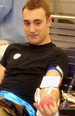 Senior Airman Christopher O'Dai, 723rd Air Mobility Squadron counter measures technician, continually squeezes a ball to help with blood flow during his unit's blood drive Dec. 13 at the 64th Replacement Battalion in the Ramstein Passenger Terminal. 
