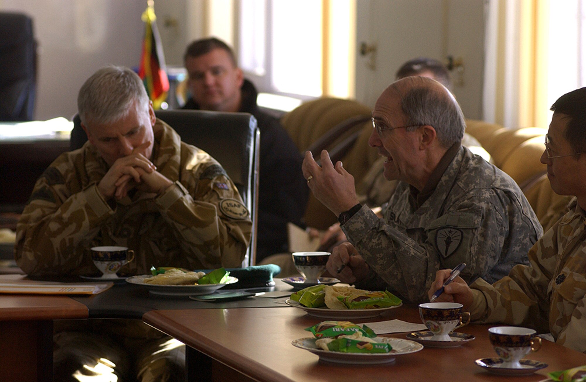 British Maj. Gen. Garry Robison, ISAF Deputy Commander of Stability, listens as Army Col. Marvin Schlatter, Base Ops Commander and Regional Commander of Kapisa, Parwan, Panshir and Bamyan Provinces, speaks during the Provincial Security Council at the Kapisa Governor's Compound Jan 4. (U.S. Army photo/Spc. Josh LeCappelain)