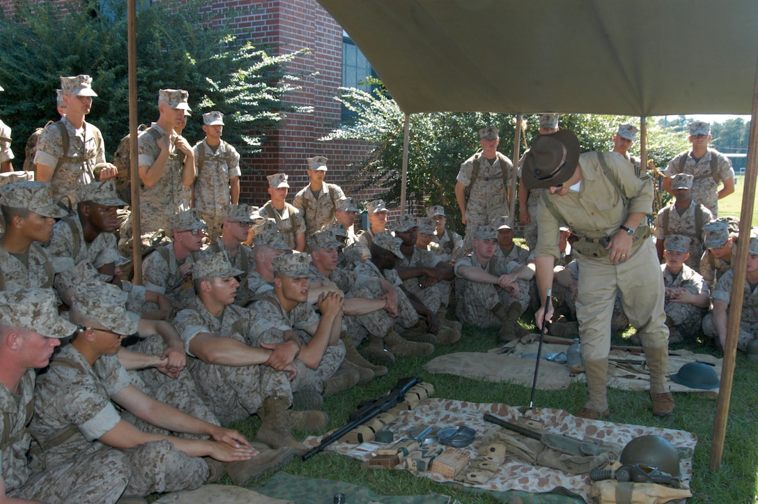 Eric Junger, training officer, assistant chief-of-staff G-3, and retired Marine major, shows Bravo Company recruits examples of how changes in equipment from World War II directly relate to the equipment used today during a living history demonstration outside the Parris Island Museum.
