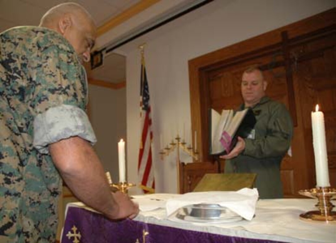 NAVAL SUPPORT FACILITY INDIAN HEAD, Md.- Petty Officer 1st Class Larry Pieper (right), a religious program specialist with Chemical Biological Incident Response Force, II Marine Expeditionary Force, helps his chaplain, Navy Cmdr. K.C. James set up for the mid-week worship service. Pieper is responsible for providing religious care to the Marines at CBIRF.