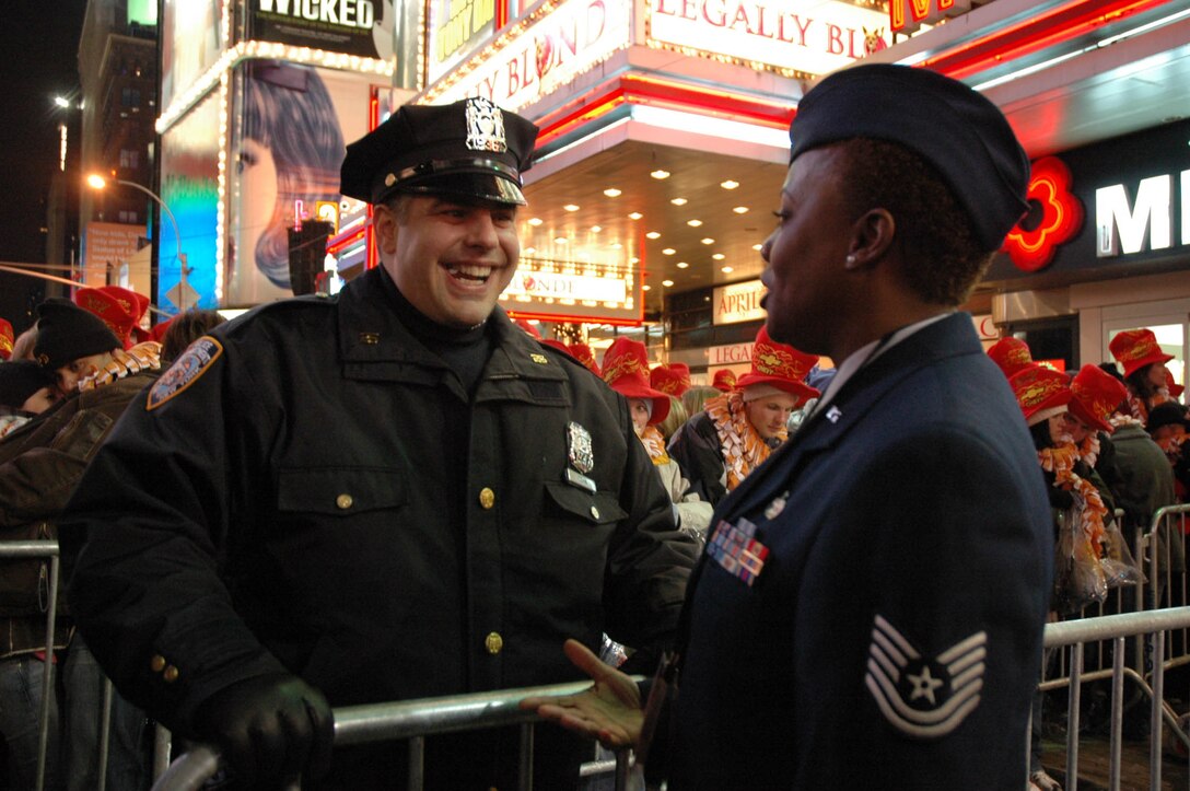 Tech. Sgt. Sonya Bulluck, Aerial Port Specialist with the Air Force Reserve Command's 514th Air Mobility Wing laughs with NYPD officer before ringing in the New Year in Times Square, New York City. The McGuire airman was selected as honorees of New York Mayor Michael R. Bloomberg. They joined nine other servicemembers from all branches of the military. (U.S. Air Force photo/Senior Airman Rachel L. Bernardes)