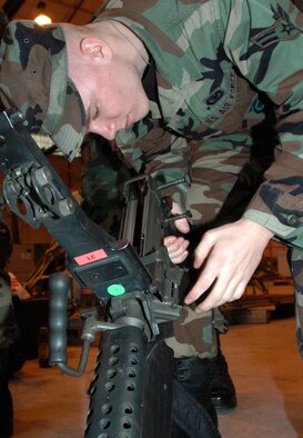 YOUNGSTOWN AIR RESERVE STATION, Ohio—Air Force Reserve Airman 1st Class Jared Thompson, a 910th Security Forces Squadron fire team member inspects a M-249 assault rifle prior to deployment.  Nine Air Force Reservists from the 910th SFS deployed to Camp Swift and Fort Hood, Texas for two weeks of weapons training prior to their deployment to Iraq in February.  Their Operation Iraqi Freedom deployment is expected to last approximately 180 days.  U.S. Air Force photo/Senior Airman Ann W. Jefferson.