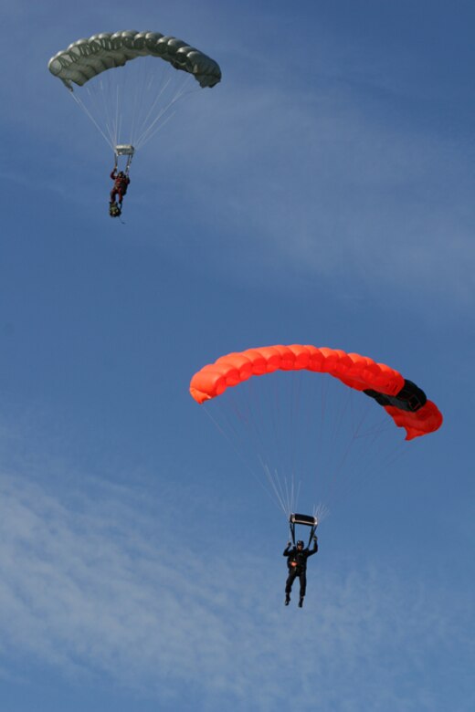 Marked by orange parachutes Canadian Rescue forces from the 435th Air Transport and Rescue Squadron deploy their parachutes as they aim for the drop zone at Canaveral Air Staion while training with Air Force Reserve Pararescumen from the 920th Rescue Wing at Patrick Air Force Base train during an international Search and Rescue Exercise Jan. 4 - 8. (U.S. Air Force Photo by Tech Sgt. Robert Grande)