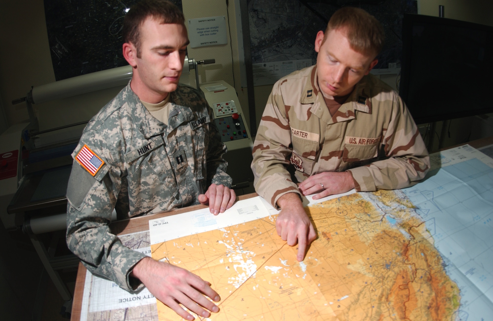 Army Capt. Eugene Hunt and Capt. Charles Carter review an aeronautical chart used by 379th Air Expeditionary Wing aircrews. Captain Hunt is a ground liaison officer with and Captain Carter is an intelligence weapons officer, both assigned to the 379th AEW. (U.S. Air Force photo/Senior Airman Ricky Best)
