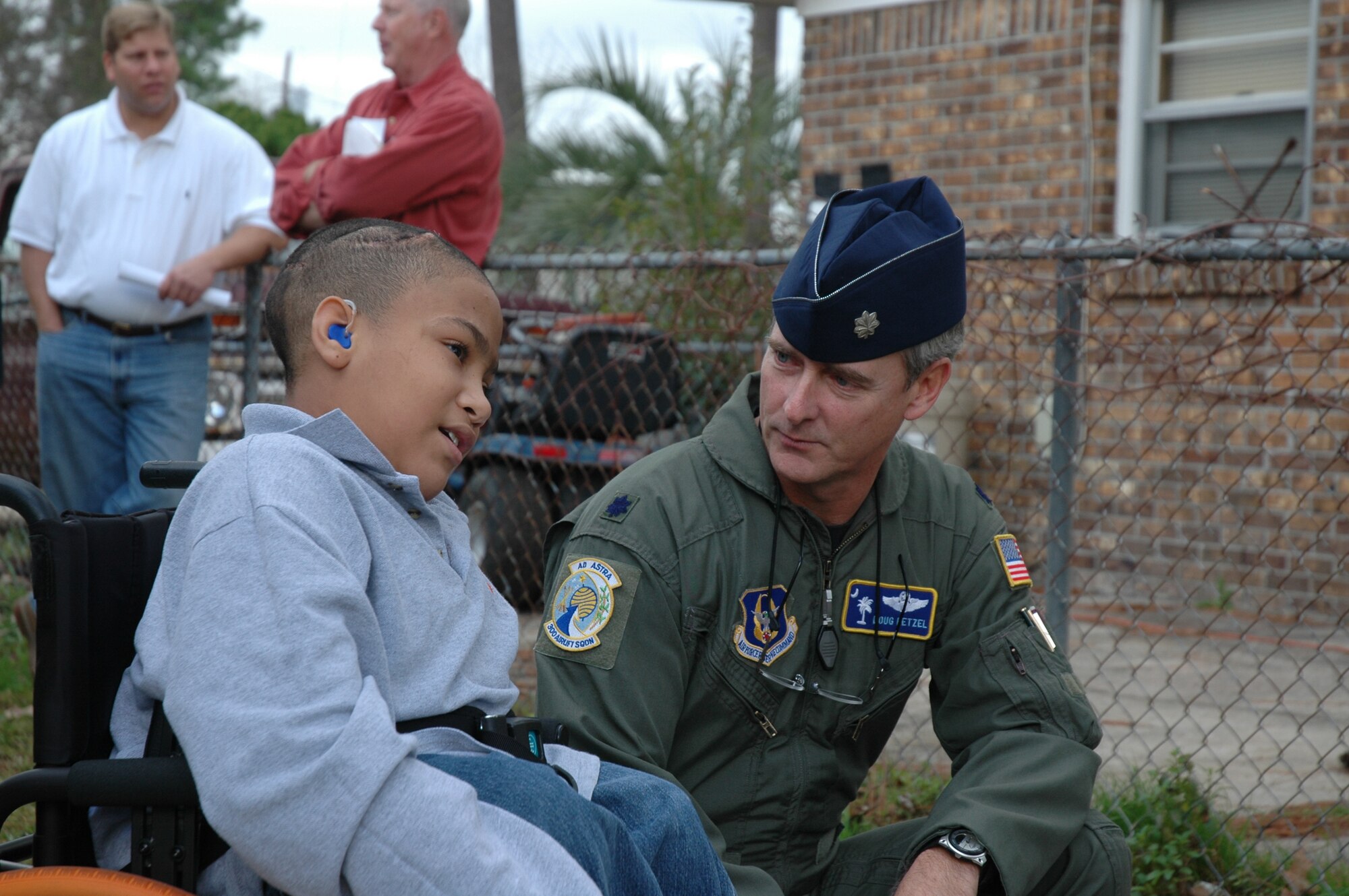 Lt. Col. Doug Hetzel (right), a reserve pilot assigned to the 300th Airlift Squadron, Charleston AFB, S.C., talks to Phillip Tracy-Curtis at the groundbreaking ceremony for Phillip's new room.  Members of the 300 AS and the local community will be building a new addition on to the Tracy-Curtis family home to better accommodate Phillip's needs.  (Photo by Staff Sgt. Jeff Kelly, USAFR)