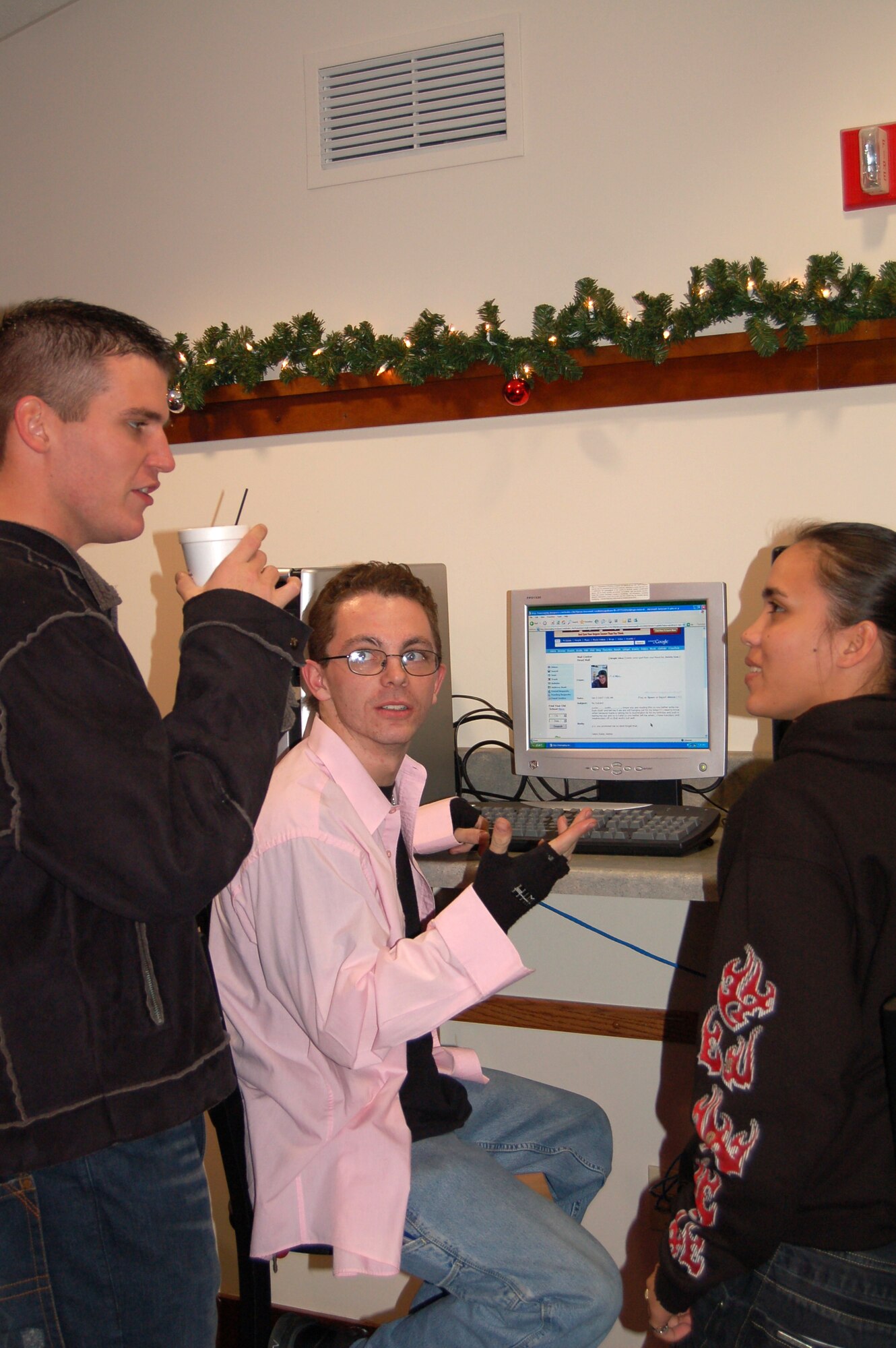 (Left to right) Airman 1st Class Steven Cash and Airman Basic Justin Russell, 436th Aerial Port Squadron, and Airman Basic Jenny Taegel, 436th Aeromedical-Dental Squadron, talk at the Eagle's Nest Coffee House Jan. 3.