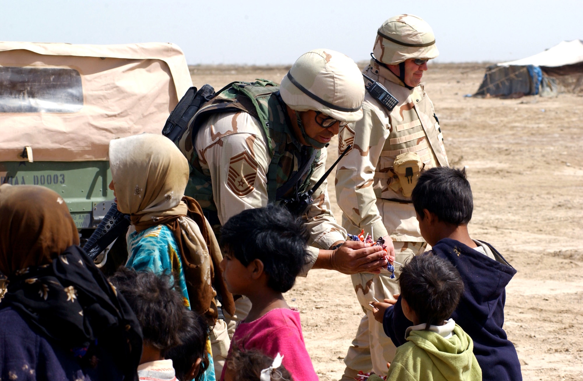 NEAR TALLIL AIR BASE, Iraq -- Senior Master Sgt. Robert Appling hands out candy to children during a visit to Bedouin camps here.  He is the fire chief assigned to the 407th Expeditionary Civil Engineer Squadron.  (U.S. Air Force photo by Master Sgt. Mark Bucher) 