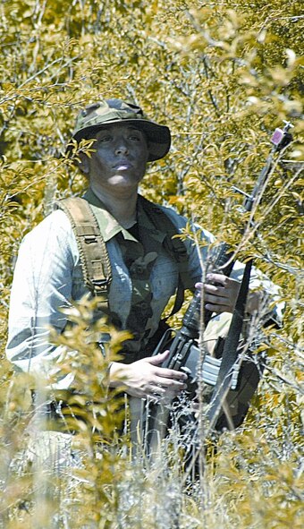 (1st Lt Jason Bishop) “Insurgent” A1C Amanda Quilantan, 71st Security Forces Squadron, spies on 71st Flying Training Wing Airmen during part of an exercise at Kegelman Airfield May 6. The weeklong exercise tested the wing’s response on base to deployment taskings as well as convoy operations off base.