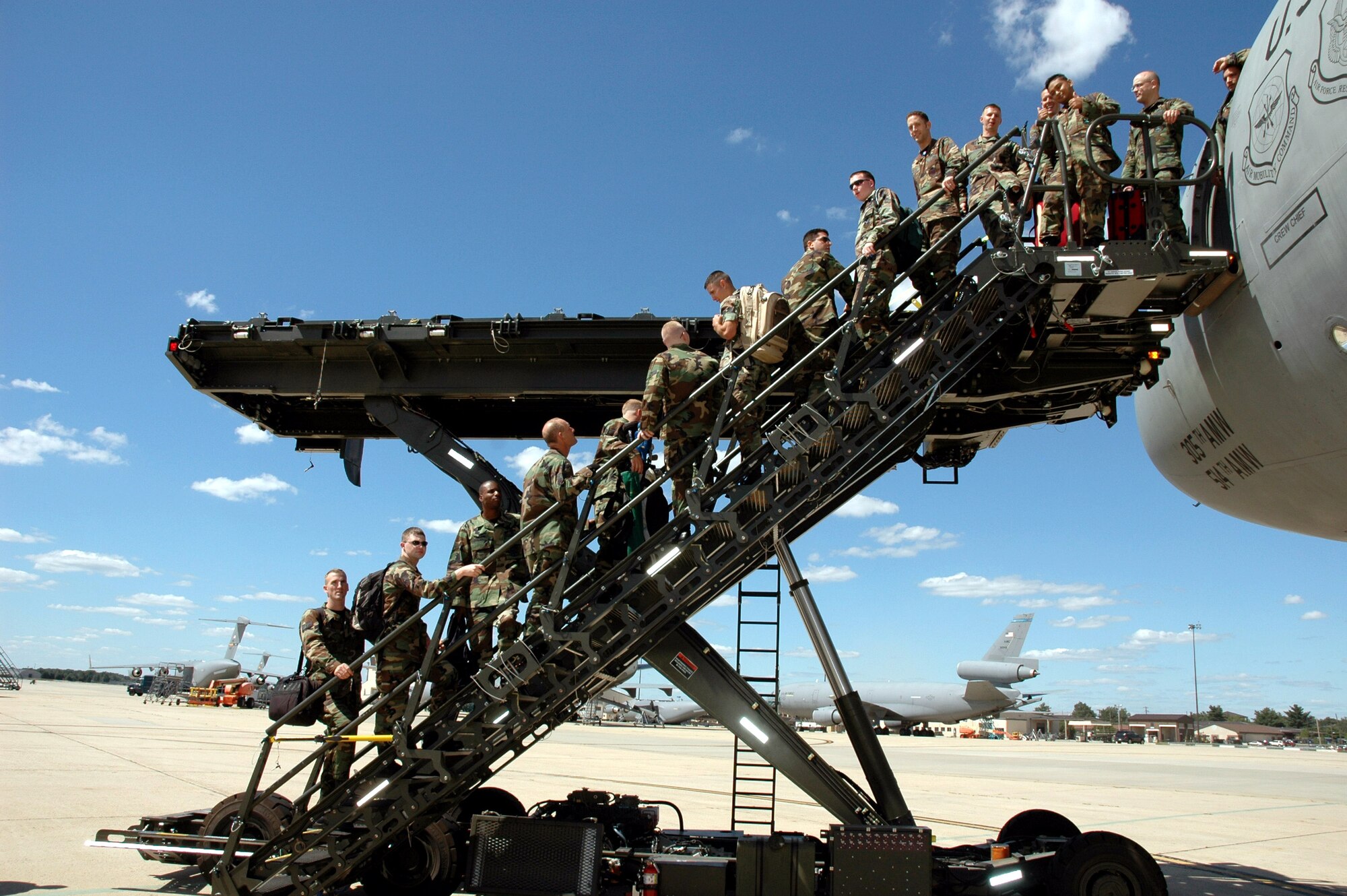 Airmen use the aircraft stairs portion of the Halvorson Air Stairs Kit-modified cargo loader during a demonstration of the loader at McGuire Air Force Base, N.J., in 2006. The development of the loader is from an initiative at the Air Mobility Warfare Center's Air Mobility Battlelab at Fort Dix, N.J. (U.S. Air Force photo)