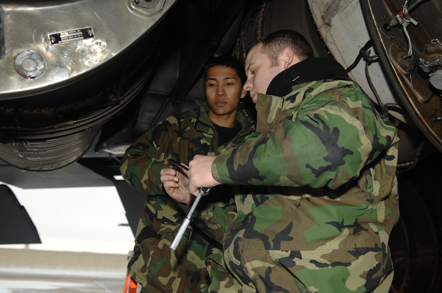 MINOT AIR FORCE BASE, N.D. – Staff Sgt. Justin McNichols (right) and Airman 1st Class Kenny Javar, both from the 5th Aircraft Maintenance Squadron, work on replacing a strut valve on a B-52H Stratofortress located on the flight line Jan.. 8. The crew endured freezing temperatures and gusts of wind up to 50 knots. (U.S. Air Force photo by Airman 1st Class Christopher Boitz)