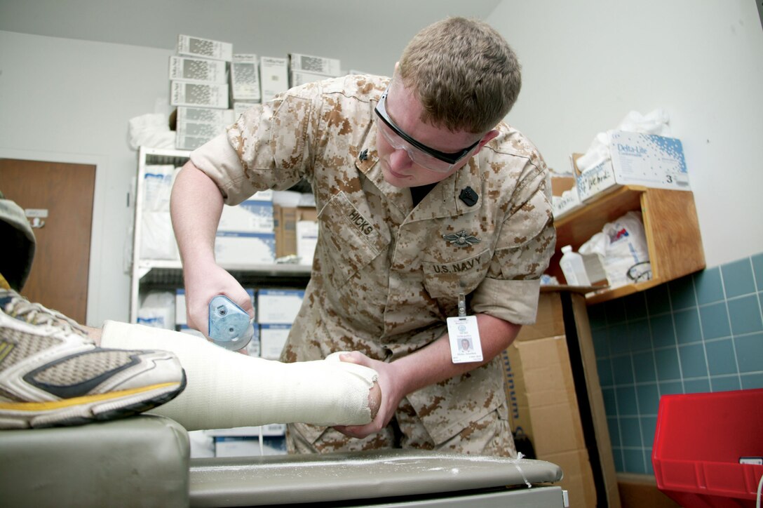 Navy Petty Officer 3rd Class Jonathan Hicks, an orthopedic technician at the Parris Island Branch Medical Clinic's Sports Medicine Department, removes a cast from a recruit's leg Oct. 9. Hicks ensures his patients are taken care of their current medical conditions improve and they can return to training.