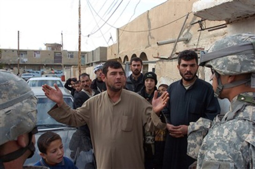 An Iraqi man talks to U.S. Army Staff Sgt. John Comito and an interpreter about conditions in Tikrit, Iraq, on Dec. 27, 2006.   Comito and his fellow soldiers are conducting a neighborhood assessment.  