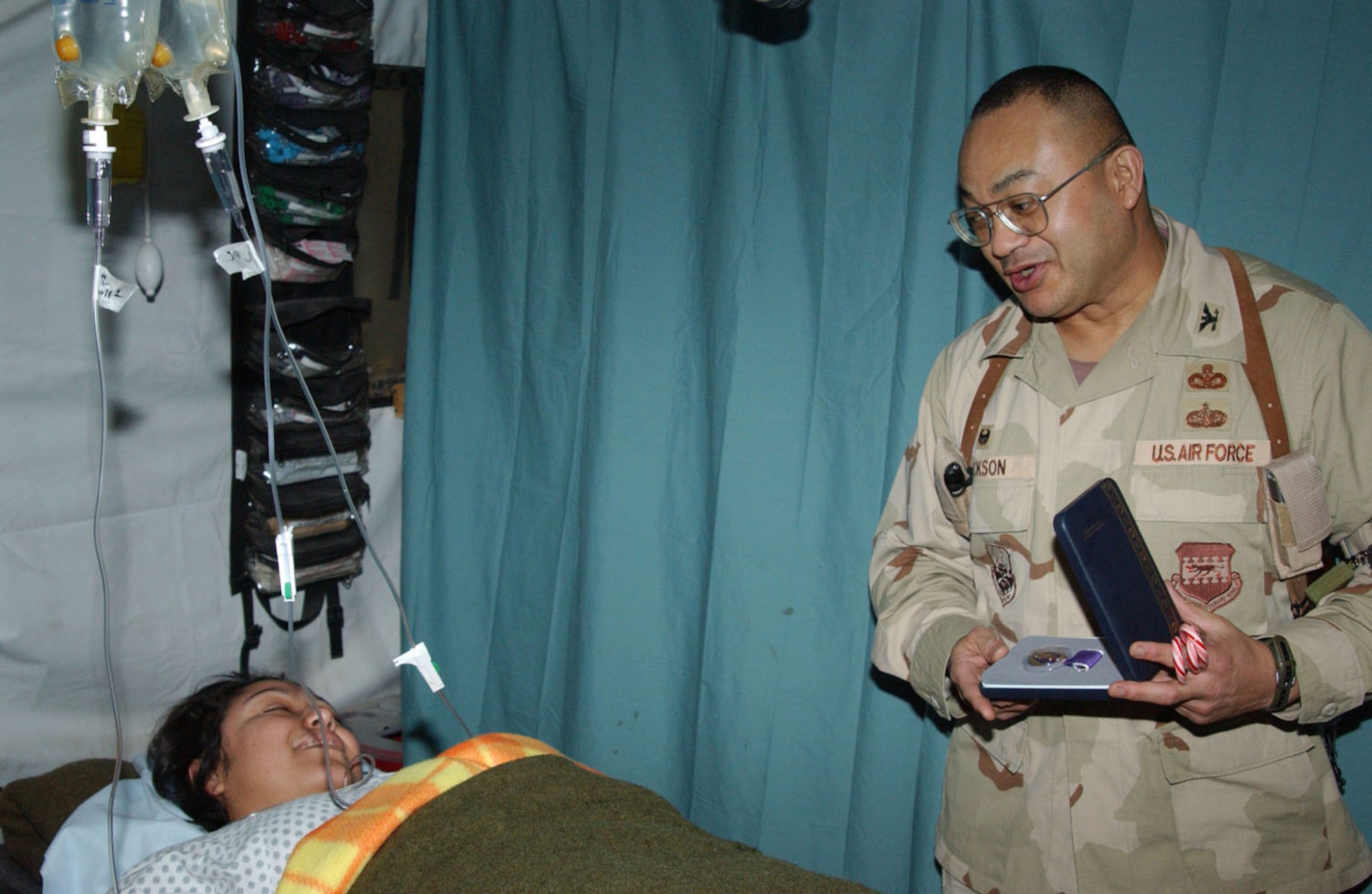 Staff Sgt. Aime Gaona receives a Purple Heart from Col. Larry Jackson for being struck by a sniper's bullet in her right femur Dec. 19 outside Kirkuk, Iraq. Sergeant Gaona is a weapons intelligence team member of the 732nd Expeditionary Civil Engineer Squadron, deployed from Luke Air Force Base, Ariz. Colonel Jackson is the 732nd Expeditionary Mission Support Group commander. (U.S. Air Force photo/Master Sgt. Kirk Clear) 