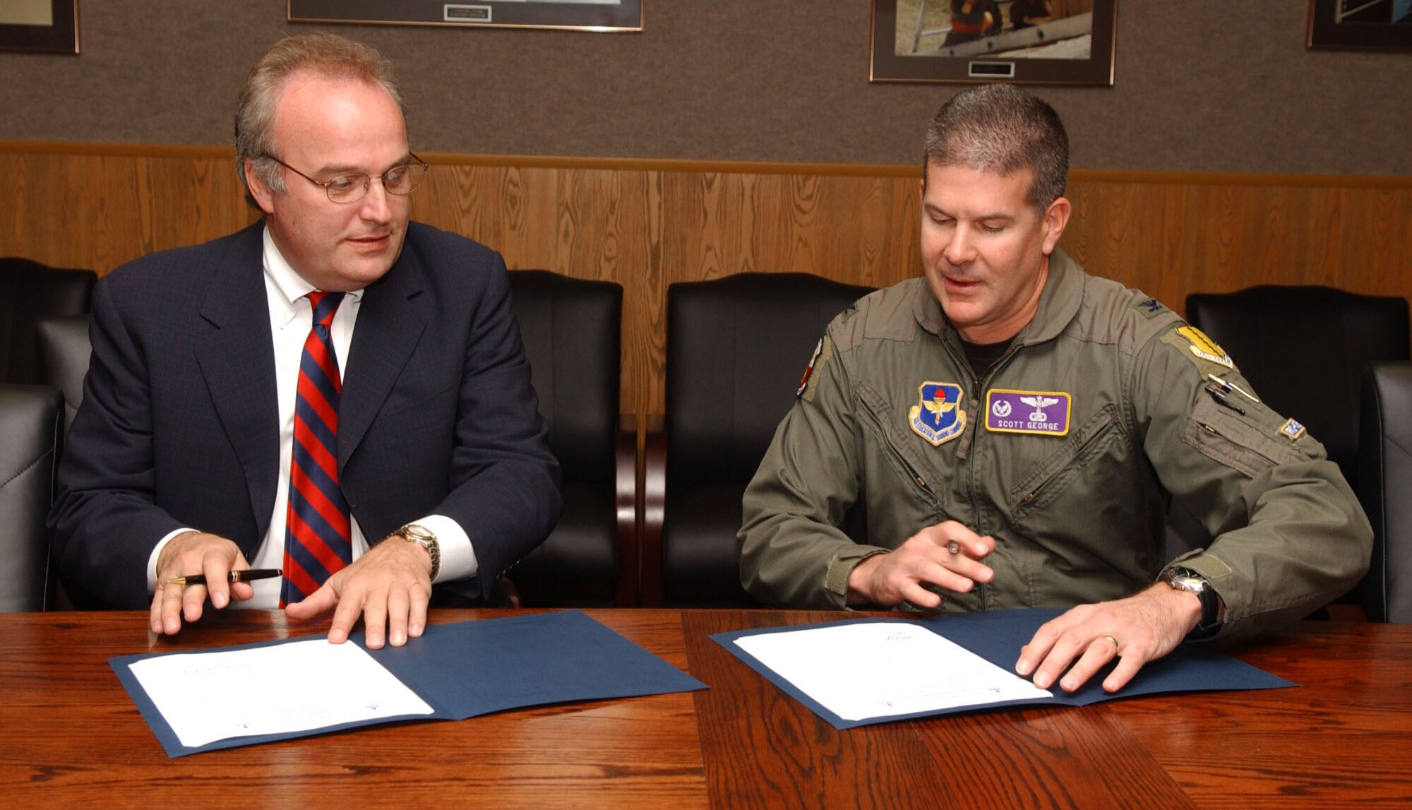 The commander of the 17th Training Group, Col. Scott George, and Mr. Wallace Boston, President of the American Public University System and American Military University, sat down to sign a memorandum of understanding Tuesday. 