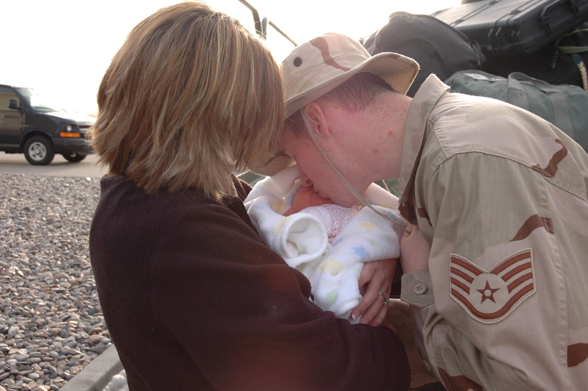 MOUNTAIN HOME AIR FORCE BASE, Idaho -- Staff Sgt. Mark Rouintree from the 391st Aircraft Maintenance Unit gives his newborn daughter, Carly, a kiss while saying goodbye to his wife, Cassi, before he boarded an aircraft Jan. 8 to deploy to Southwest Asia. The sergeant was one of nearly 250 Airmen from the 366th Fighter Wing who deployed Jan. 7 and 8 in support of the Global War on Terrorism. Air Force photo by Master Sgt. Brian S. Orban