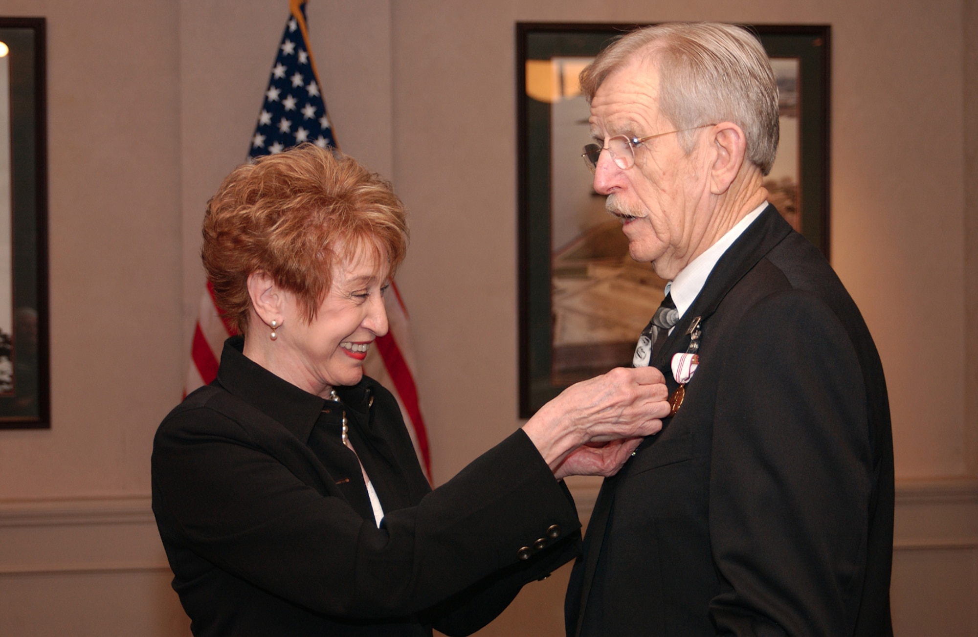 Peggy Daniel, wife of Dan Daniel, 314th Airlift Wing Equal Opportunity Program Manager, pins the retirement pin on him during a ceremony Jan. 5. 