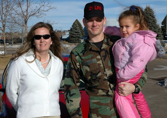 Tech. Sgt. John Berquist, a logistics planner for the 21st Logistics Readiness Squadron, holds Jackie Cubas, daughter of Janet Cubas, small business office. Sergeant Berquist took being a good Wingman seriously Dec. 20 when he not only pushed Ms. Cubas’ car out of the Child Development Center’s snow-slick parking lot, but also followed her home. When her car could not climb a hill near her home, Sergeant Berquist took Ms. Cubas and her daughter the rest of the way home in his truck.
Sergeant Berquist said he lives only a few blocks from Ms. Cubas, and also works with her husband, and he takes the same route home.
“He also had his own baby boy in the truck to worry about,” Ms. Cubas said. “I am so grateful he was there to help.” (U.S. Air Force photo by Steve Brady)
