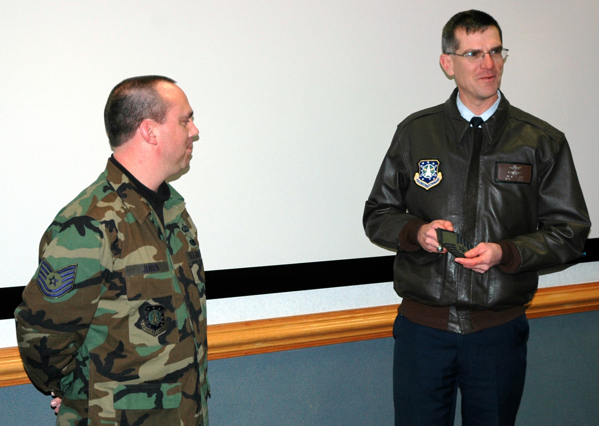 Tech. Sgt. Greg Jensen, a contracting specialist supervisor with the 21st Contracting Squadron, got a new stripe with a STEP promotion Jan. 5. Col. Jay G. Santee, 21st Space Wing commander, surprised Sergeant Jensen with the master sergeant stripes at the civil engineer conference room. (U.S. Air Force photo by Senior Airman Jessica Switzer)