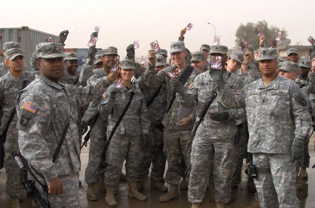 Soldiers in Kuwait hold up pre-paid calling cards on Valentine's Day. The cards were sent by Cell Phones for Soldiers, a Massachusetts-based nonprofit group that uses money from recycling cell phones to purchase phone cards for deployed servicemembers. Cell Phones of Soldiers co-founder Robbie Bergquist has been named a finalist in the Angel Soft "Angels in Action" Award Program for his efforts to keep servicemembers and their families connected. Courtesy photo