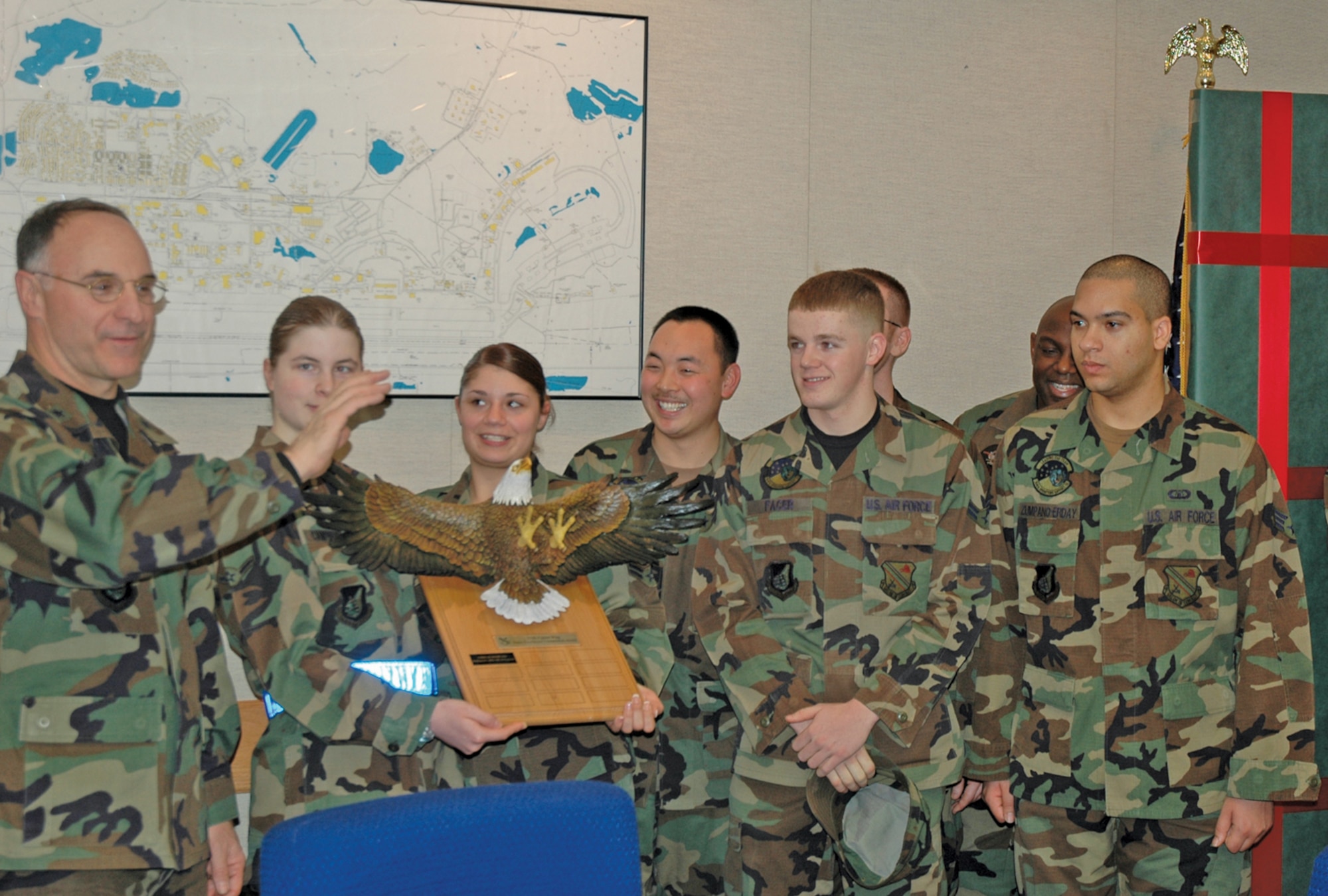 EIELSON AIR FORCE BASE, Alaska--The 4th Quarter Dorm Excellence Competition winners receive the winning plaque from Brig. Gen. Dave Scott, 354th Fighter Wing commander, at the Jan. 4 wing staff meeting. The winning dormitory was building 2353, housing single Airmen from the 354th Medical Group, 354th Operations Squadron, 354th Services Squadron, 354th Comptroller Squadron and Detachment 460.