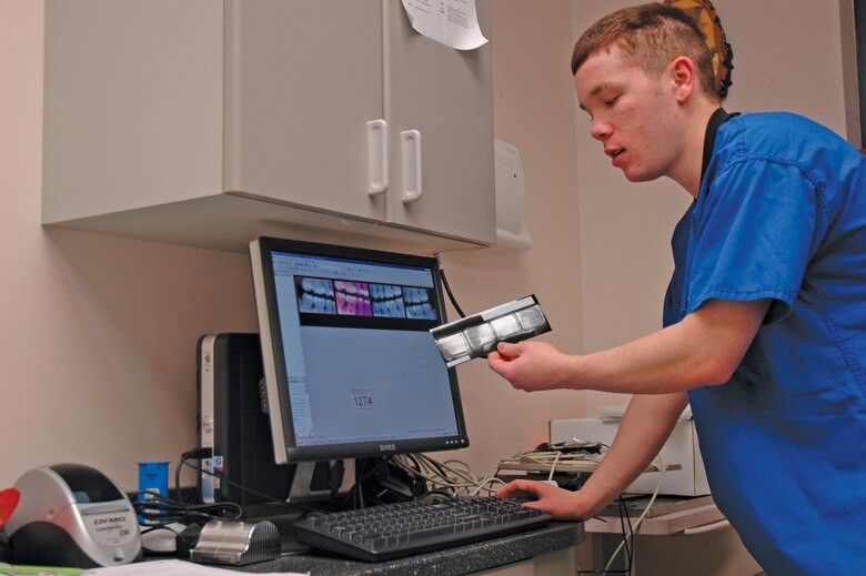 EIELSON AIR FORCE BASE, Alaska--Airman 1st Class Paul Brown, 354th Medical Operations Squadron dental technician, explains the difference between film and digital dental X-rays at the base dental clinic Wednesday morning. The digital X-rays provide options unavailable with film, such as colorization, zooming and magnification of X-rayed areas. If a film X-ray is too dark or light, it must be retaken, while digital X-rays can be adjusted accordingly. (U.S. Air Force photo by Staff Sgt. Gloria Wilson)