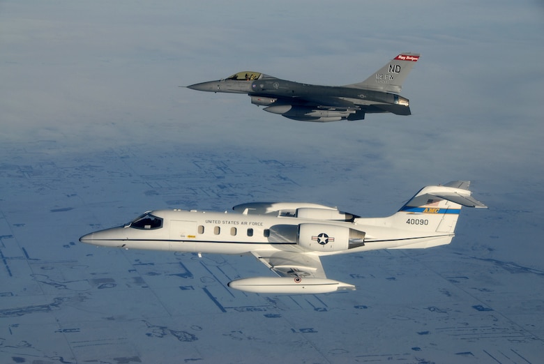 Capt. Stephanie Kelsen pilots a North Dakota Air National Guard F-16 Fighting Falcon alongside the first C-21 to join the 119th Fighter Wing as it flies Jan. 10 into Fargo, N.D. Lt. Col. Craig Schroeder and Maj. Jon Wutzke of the 178th Fighter Squadron are flying the C-21 as it arrives in Fargo for the first time. Captain Kelsen is also from the 178th FS. The C-21 aircraft is considered a "bridge mission" until approximately 2010 when it is expected to be replaced by the new "Joint Cargo Aircraft."  (U.S. Air Force photo/Senior Master Sgt. David Lipp)