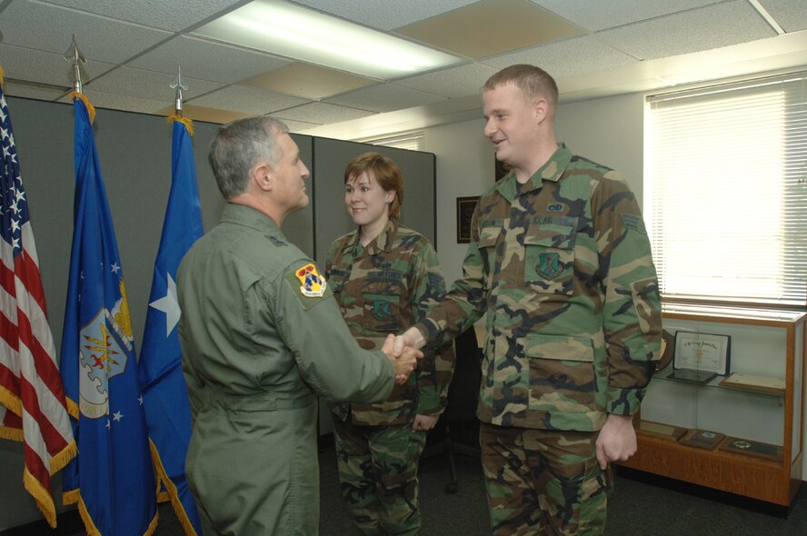 Maj. Gen. James Hawkins, 18th Air Force commander, shakes Senior Airmen Grant Peterson's hand after his re-enlistment. (photo/Airman 1st Class SerMae Lampkin)