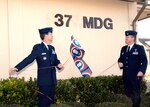 Brig. Gen. Darrell Jones, then the 37th Training Wing commander, and Col. Tim Halligan, then the commander of the newly reactivated 37th Medical Group, unveil the group's abbreviation on its headquarters building across Biggs Avenue from the Warhawk Fitness Center. General Jones led the Dec. 22, 2006, ceremony to reactivate the group, the first medical assets under direct control of the 37th TRW since Wilford Hall Medical Center was completed in 1957. (USAF photo by Robbin Cresswell)