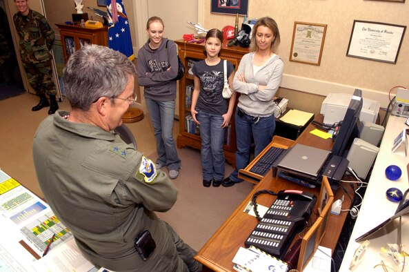 Maj. Gen. Jeffrey Riemer, program executive officer for weapons and Air Armament Center commander, congratulates Tech. Sgt. Dennis Barnett, 96th Security Forces Squadron, on his Stripes For Exeptional Performers promotion Jan. 9 while his wife and daughters look on. Sergeant Barnett is currently deployed.