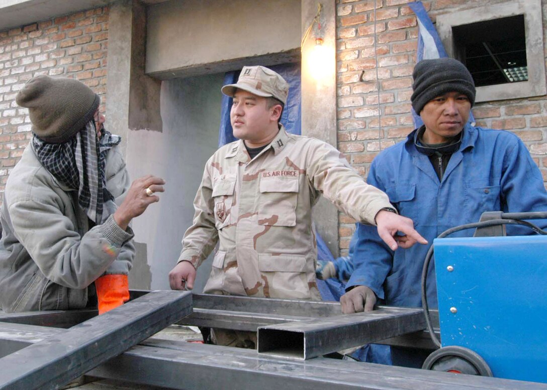 Capt. Dave Lin discusses details regarding the camp's new conference center with site engineer Renato Jan. 11 in Afghanistan. Captain Lin is an engineer with the International Security Assistance Force headquarters. (U.S. Air Force photo) 
