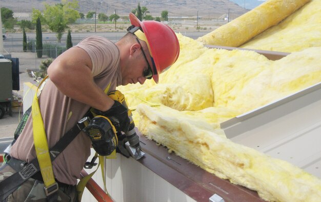 Senior Airman Ken Urey, structural craftsman for the 820th REDHORSE Squadron, attaches braces to secure roof panels onto the 42nd Attack Squadron’s new administration facility at Creech. The new building is just one of a series of projects REDHORSE is in the process of completing. U.S. Airt Force Photo by Capt. Steve Thomas