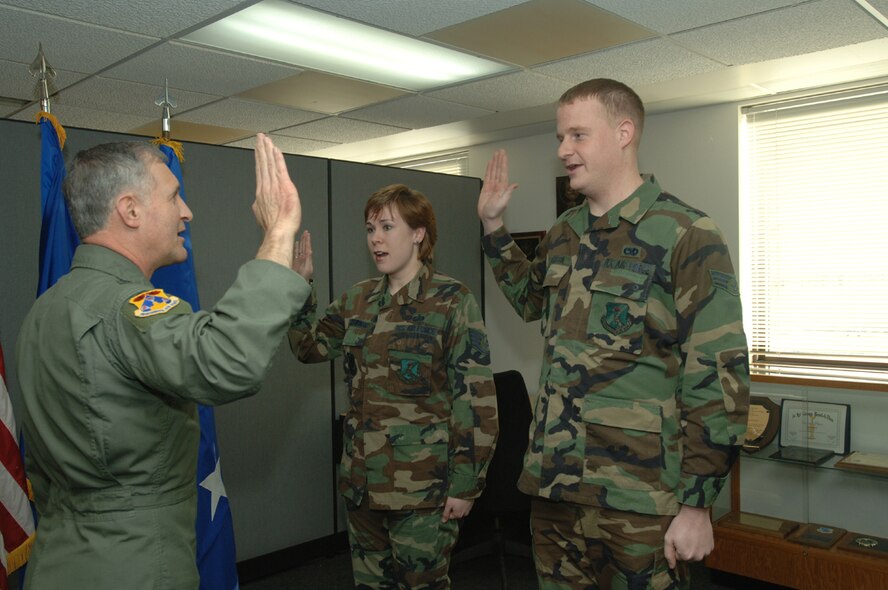 Maj. Gen. James Hawkins, 18th Air Force commander, re-enlists two Airmen. (photo/Airman 1st Class SerMae Lampkin)