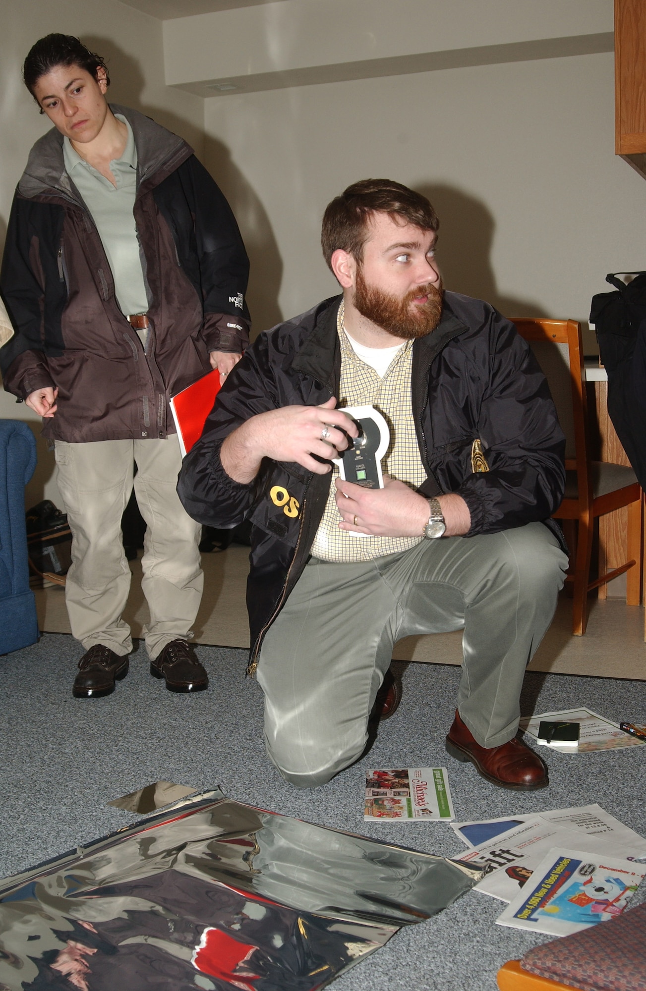 MCCHORD AIR FORCE BASE, Wash. --
Special Agent Daniel Tyler prepares to use an electrostatic dust lifter to find evidence at a simulated crime scene as Special Agent Adrianna Vorderbruggen looks on.
(U.S. Air Force Photo/Randy White)              