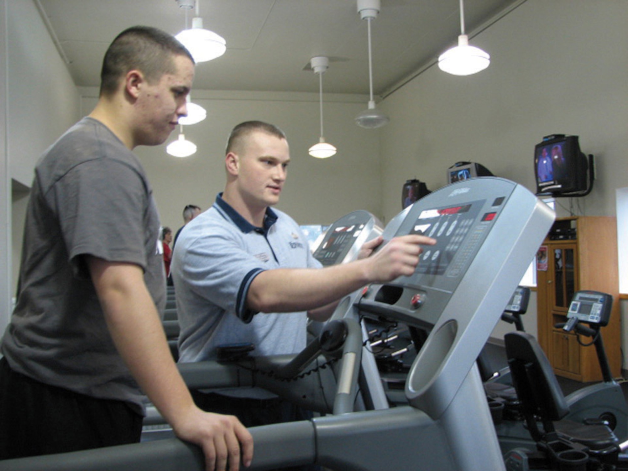 MCCHORD AIR FORCE BASE, Wash. -- Personal trainer Staff Sgt. Noah Grayson, 62nd Services Squadron, works with Airman 1st Class Travis Morrill, 62nd SVS, to select the appropriate settings on a treadmill so that Airman Morrill can get a good cardiovascular workout at the Fitness Center Annex recently.
(U.S. Air Force Photo/Staff Sgt. Tiffany Orr)