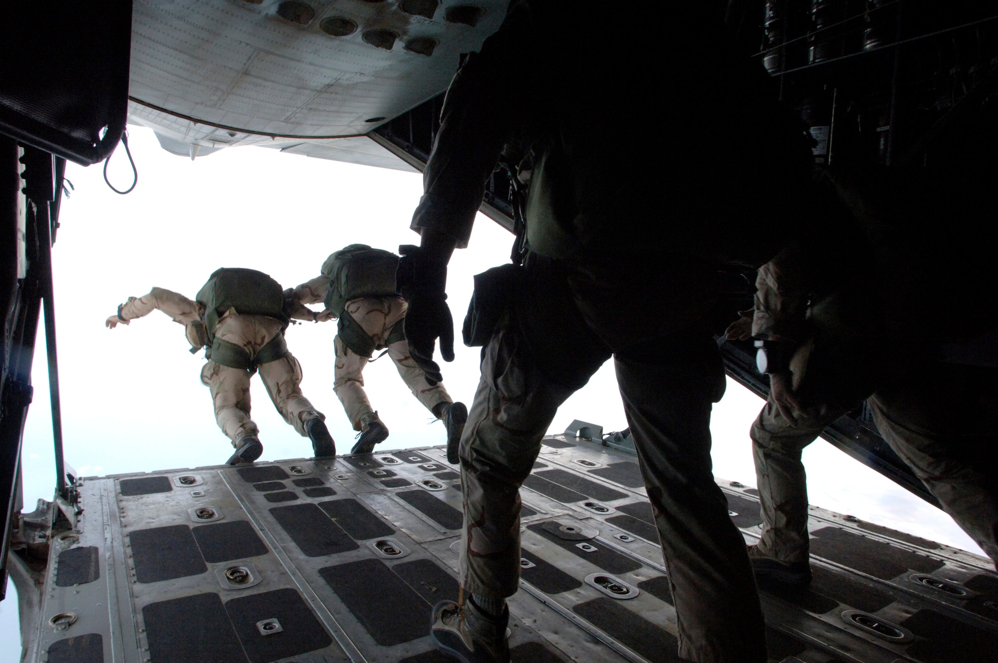 Pararescue jumpers begin their free-fall from 10,000 feet from the cargo ramp of a C-130 Hercules above Camp Lemonier, Djibouti. The training helps Airmen deployed from Davis-Monthan Air Force Base, Ariz., stay proficient in jump skills. (U.S. Air Force photo/Master Sgt. Scott Wagers)