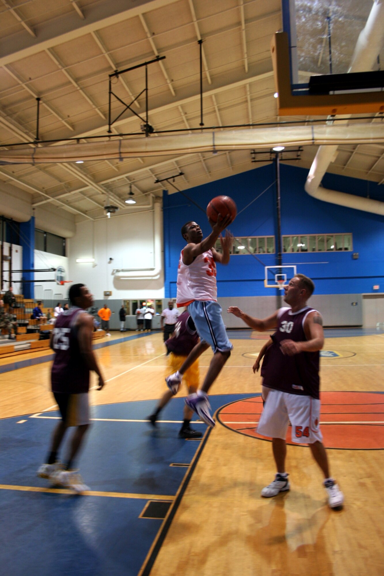 Dereck Lewis, center, soars above 1st Special Operations Communications Squadron intramural basketball players Monday at the Aderholt Fitness Center. Lewis led the 1st Special Operations Support Squadron team with 12 points to win, 36-35. (U.S. Air Force Photograph by Dylan Laurie)