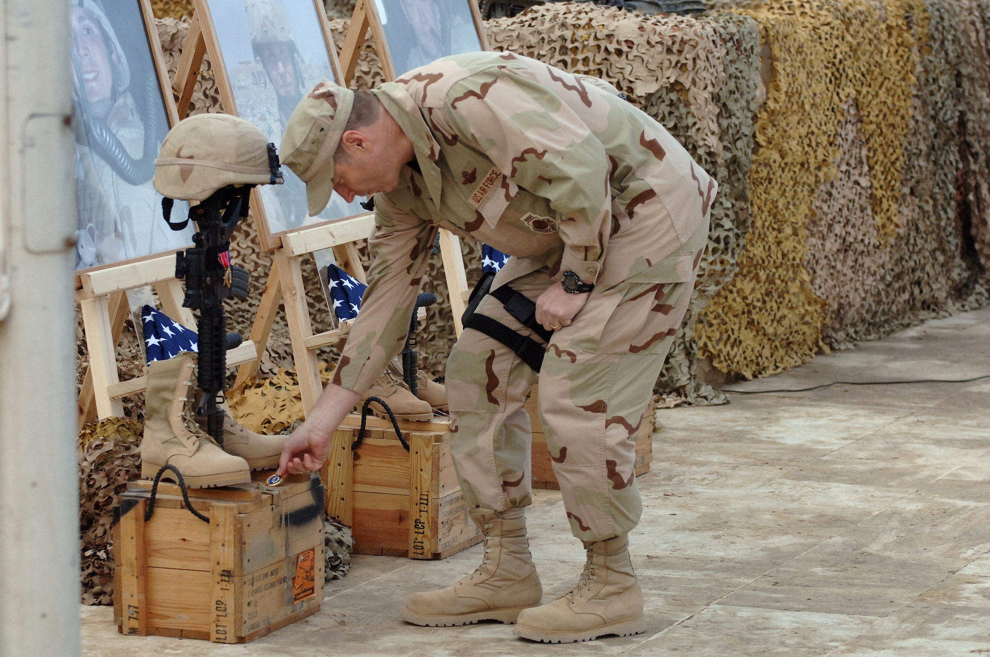 Brig. Gen. Robin Rand, the 332nd Air Expeditionary Wing commander, places one of his coins on the memorial display for Tech. Sgt. Timothy Weiner during a memorial service at Sather Air Base, Iraq, Jan. 10.  Sergeant Weiner, Senior Airman Daniel Miller and Senior Airman Elizabeth Loncki were killed in the line of duty Jan. 7 when a vehicle-borne improvised explosive device they were investigating detonated.  (U.S. Air Force Photo/Staff Sgt. Scott McNabb)