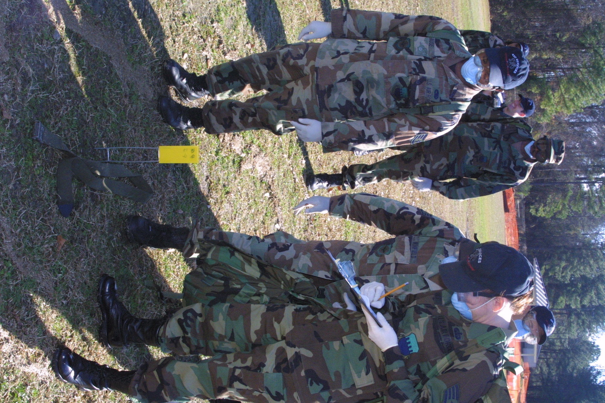 Search and Recovery Team members walk abreast and scan the ground around them after each step as they search for anything that could be remains or personal effects.