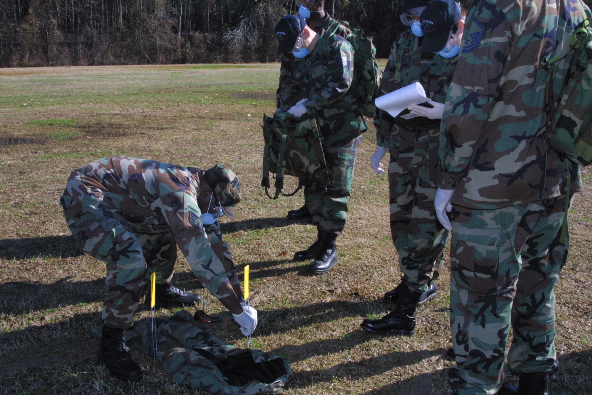 Search and Recovery Team members walk abreast and scan the ground around them after each step as they search for anything that could be remains or personal effects.