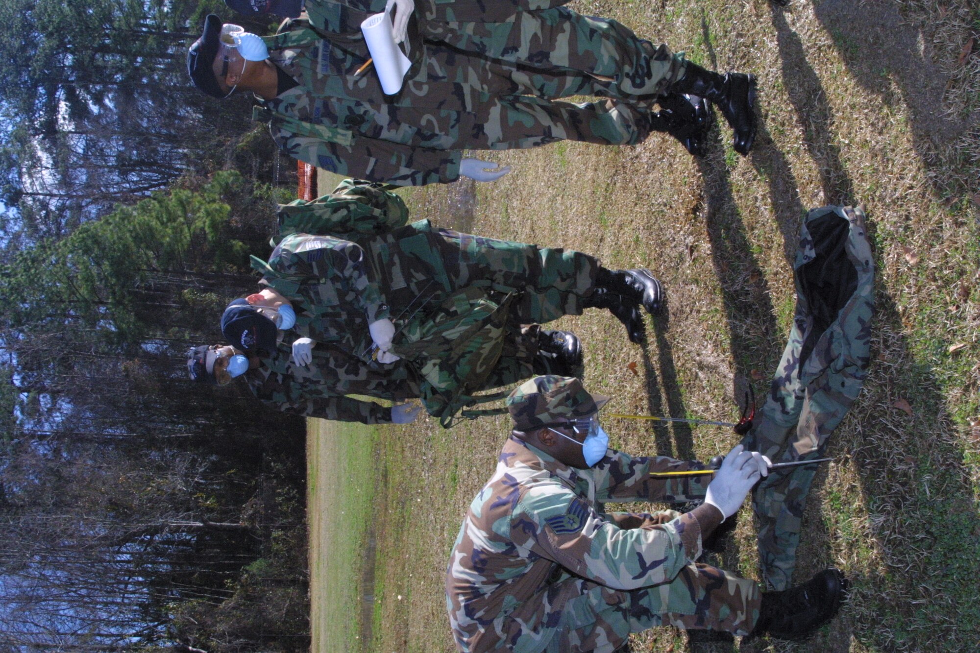 Search and Recovery Team members walk abreast and scan the ground around them after each step as they search for anything that could be remains or personal effects.