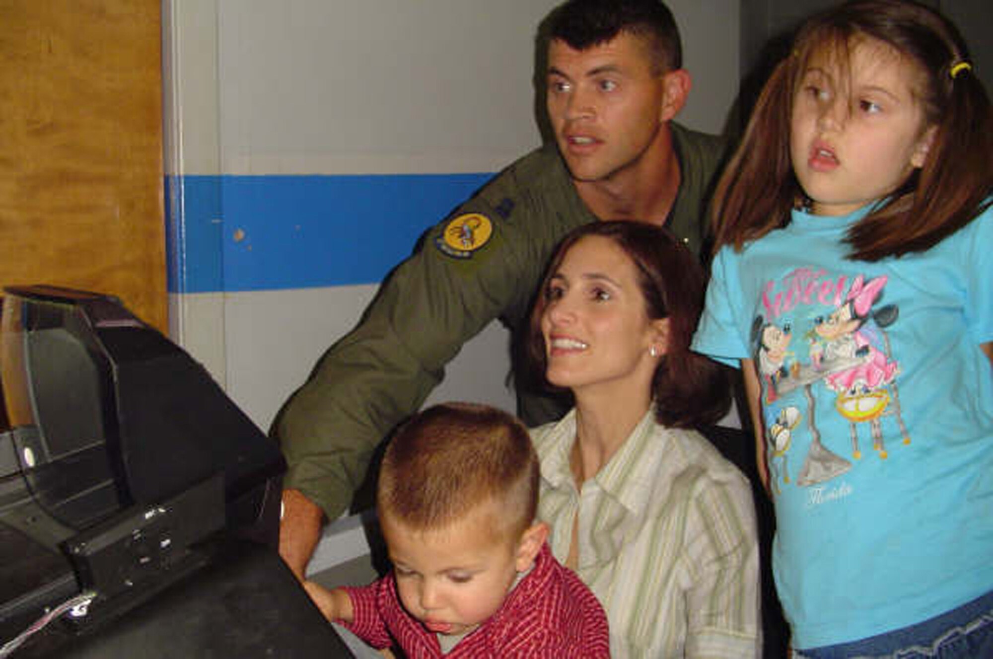 EGLIN AFB, Fla -- Jen Gockley takes her turn in an F-16 simulator while Capt. Richard Gockley, 28th Test and Evaluation Squadron, and their children Ally, 6, and Max, 2, give her pointers on how to fly. Not pictured is their 4-year-old son Ryan. The family attended a red carpet simulator ride hosted by the 29th Training Systems Squadron during the holiday season. (U.S. Air Force Photo by Tech. Sgt. Andrew Leonhard)