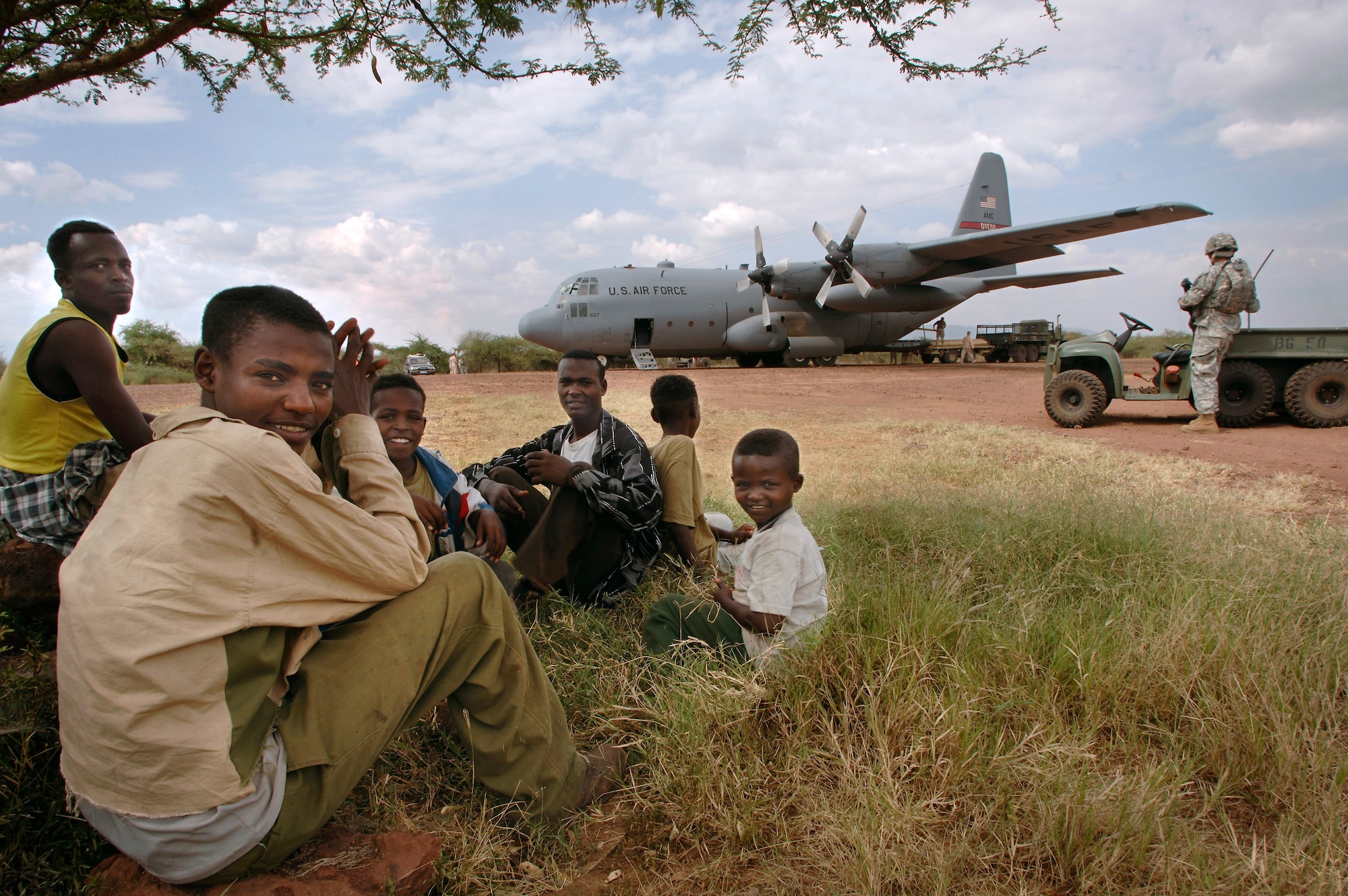 Ethiopians from the nearby village of Bilate come out to view a C-130 Hercules deployed from Dyess Air Force Base, Texas. The 4,500-foot dirt runway is the only airstrip available for delivering passengers and cargo to a U.S. contingency operating base in the remote village. (U.S. Air Force photo/Master Sgt. Scott Wagers)