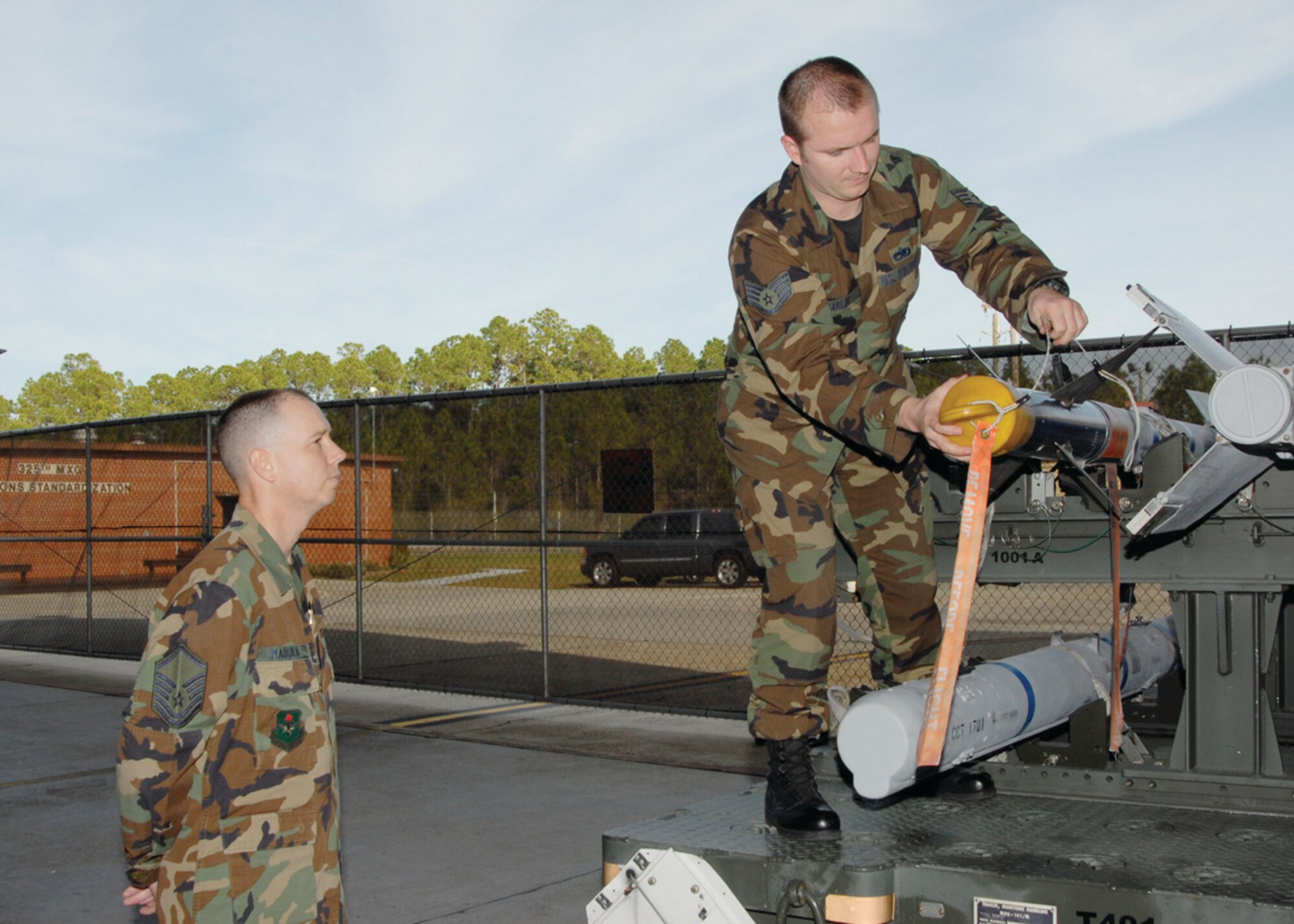 Sergeant Madura evaluates Staff Sgt. Heath Marlin’s, weapons standardization lead crew chief, inspection of an AIM-9 missile.