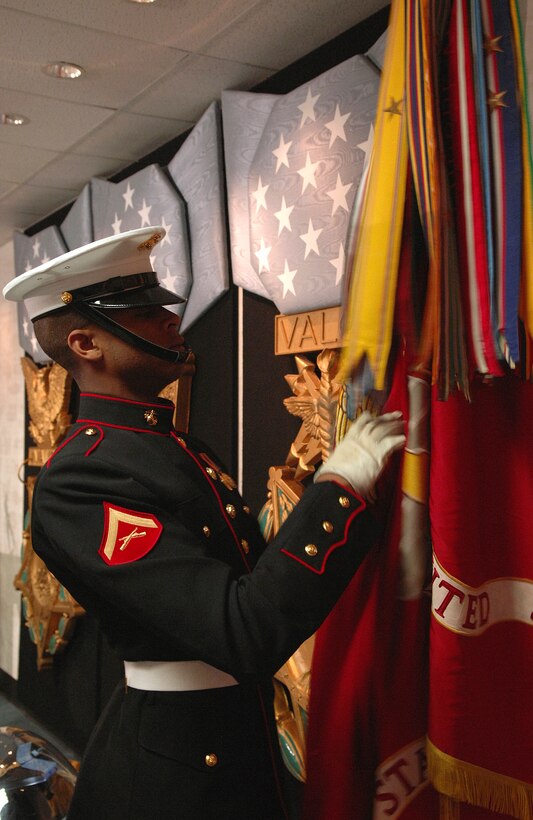 U.S. Marine Corps Lance Cpl. Trey Sheldon adjusts the U.S. Marine Corps flag prior to the ceremony inducting Cpl. Jason L. Dunham into the Pentagon Hall of Heroes, Jan. 12, 2007.
