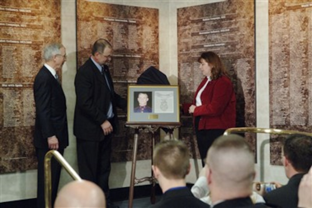 Mr. and Mrs. Dan Dunham unveil the photograph and citation of the Medal of Honor of their son U.S. Marine Cpl.  Jason Dunham at the Pentagon on Jan. 12, 2007.  Dunham received the medal posthumously for his heroic actions in Iraq.  Deputy Secretary of Defense Gordon England (left) looks on. 