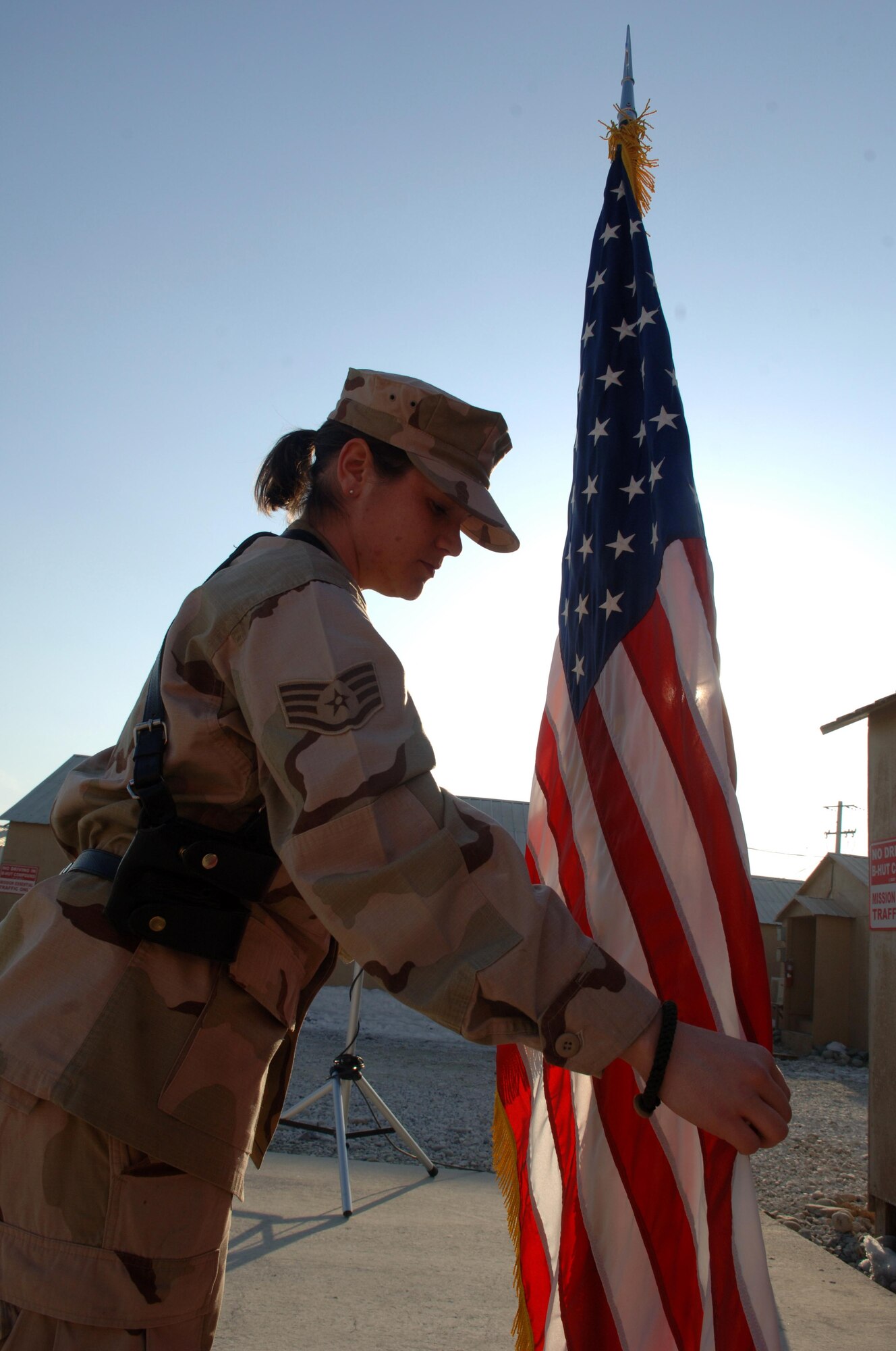 Staff Sergeant Deborah Fisher, 455th Air Expeditionary Wing Protocol noncommisioned office in-charge, positions the United States flag prior to a change of command ceremony January 11. As the Protocol NCOIC, she is responsible for the execution of ceremonial and wing events to include visits from U.S. and foreign leaders. Sergeant Fisher is deployed from Peterson Air Force Base.