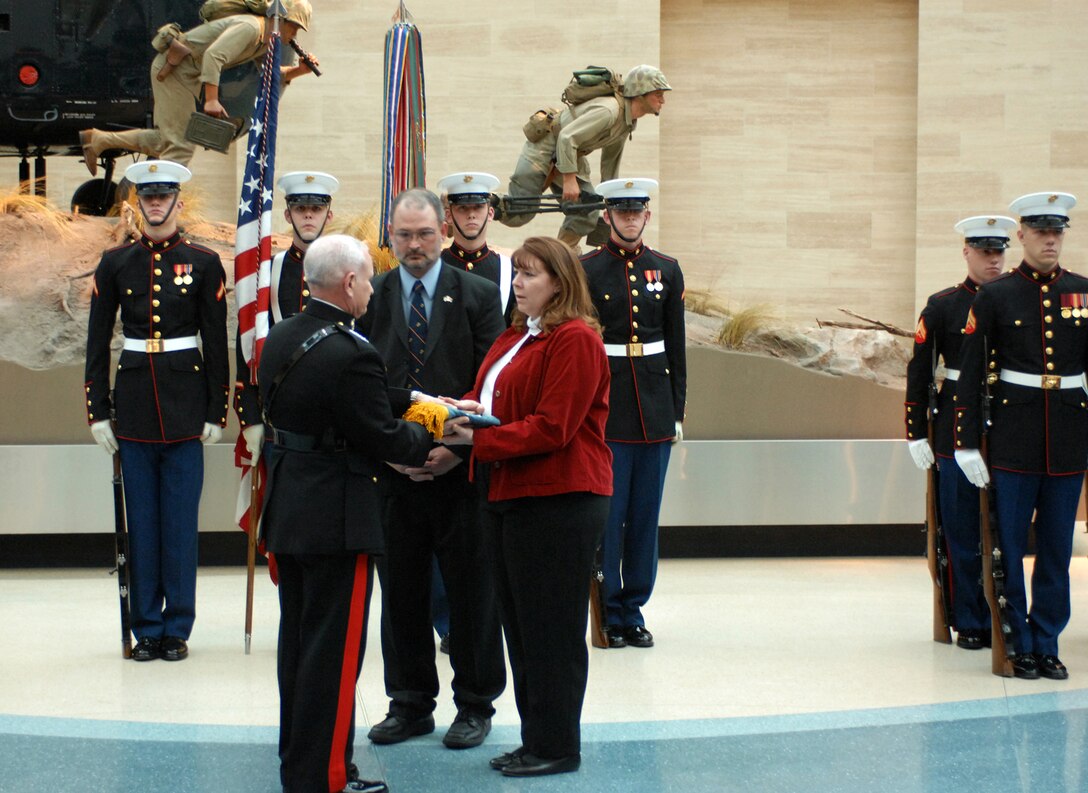 Marine Gen. Robert Magnus, assistant commandant of the U.S. Marine Corps, presents Deb and Dan Dunham with the Medal of Honor Flag during a ceremony honoring their son, U.S. Marine Cpl. Jason L. Dunham, at the National Museum of the Marine Corps, in Quantico, Va., Jan. 12, 2007. Dunham died in Iraq in 2004 while shielding fellow Marines from a grenade blast.