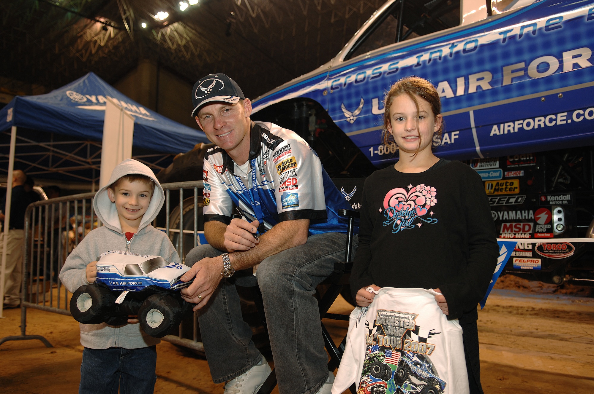 Damon Bradshaw, driver of the Air Force sponsored monster truck Afterburner, poses with young fans Ethan and Brooke during the Party in the Pits prior to the start of the 2007 Monster Jam in San Antonio, Texas, January 13, 2007. Ethan and Brooke are the children of Tech. Sgt. Bryce VanDevender, 37th Security Forces Squadron, Lackland AFB, TX. (US Air Force photo/Master Sgt. Scott Reed)